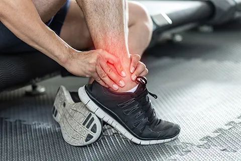 man holding sprained ankle