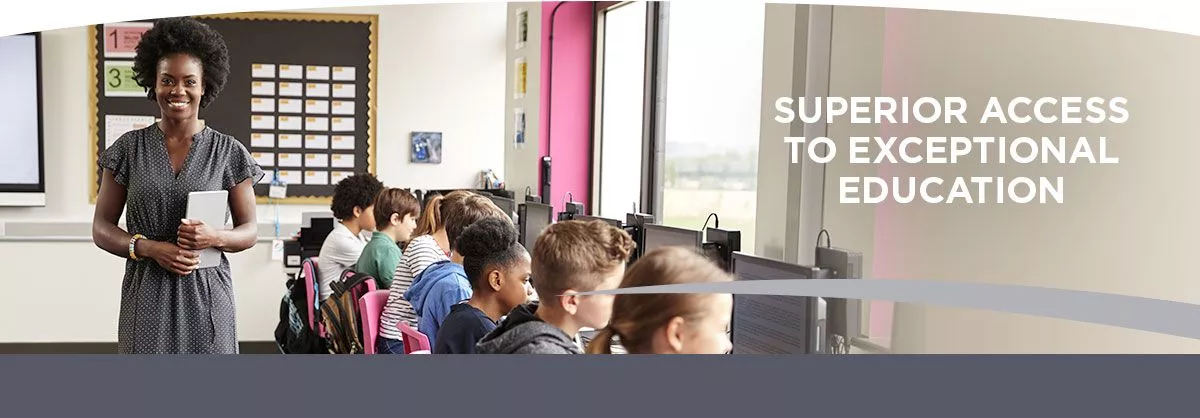 teacher overlooking students working on computers